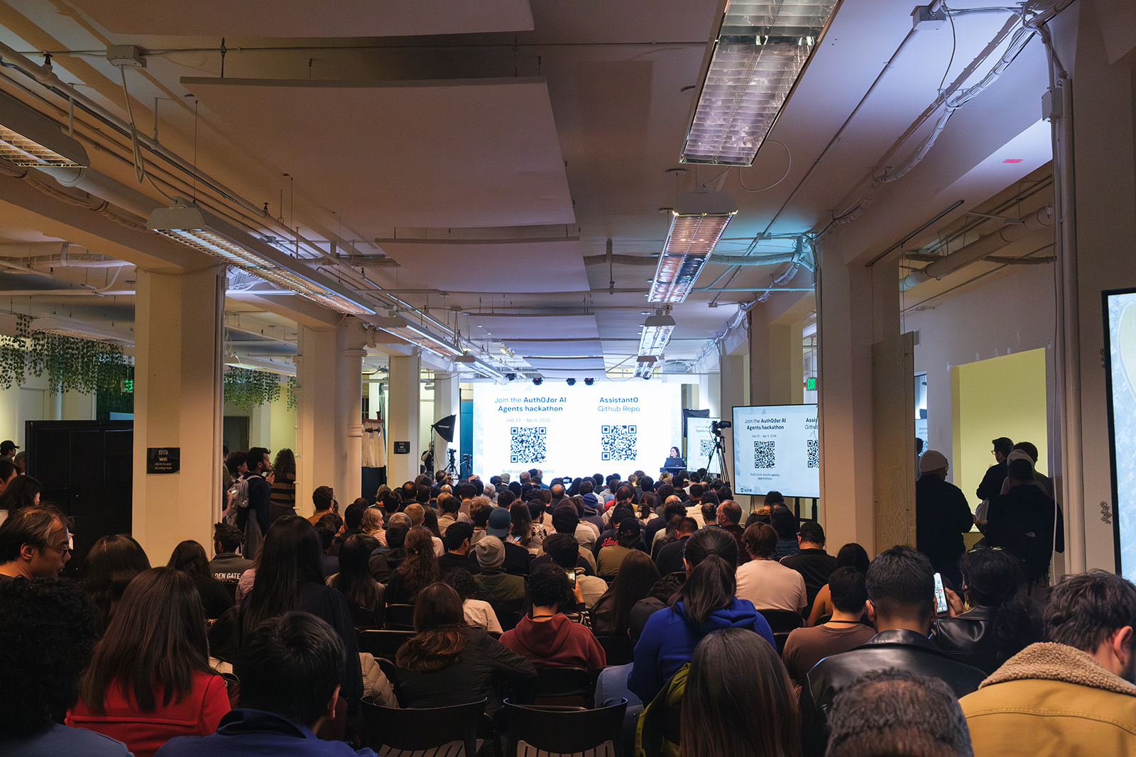 A packed audience at the Auth0 for AI Agents hackathon watching a presentation